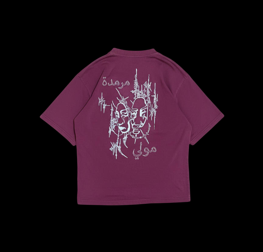 Back of a burgundy tee with white embroidered masks, thorned lines and Arabic lettering