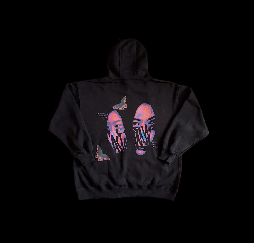 Back of a black hoodie printed with two faces in pink and blue, crossed by the Ashtray wordmark, and two butterflies